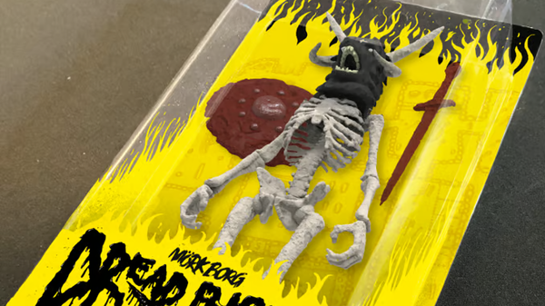 Mock up of MÖRK BORG's official Dread Risen action figure, a skeleton in a plastic slipcase with yellow backing