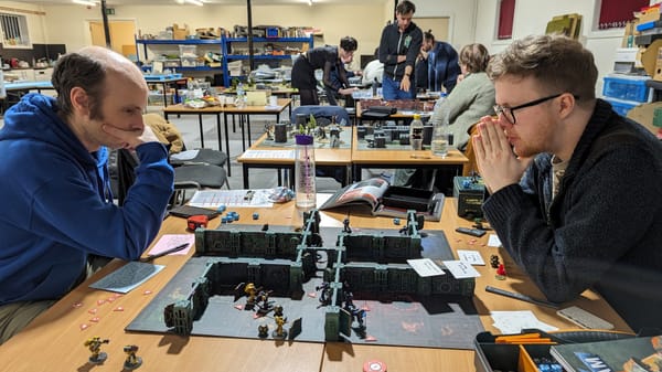 Two very lovely chaps engaged in deep thought over a game of Kill Team.