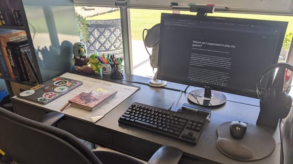 My work desk with a keyboard, mouse and wall calendar on its surface. The screen is open to a draft of this article.