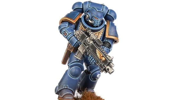 A photo of a Warhammer 40,000 miniature: an Ultramarine Intercessor in blue and gold armour