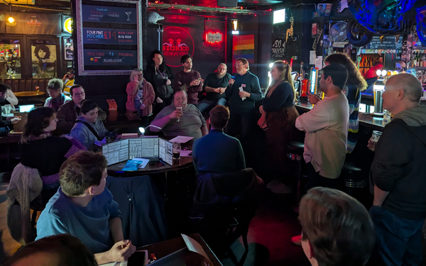 A group of 20 people sit around a bar