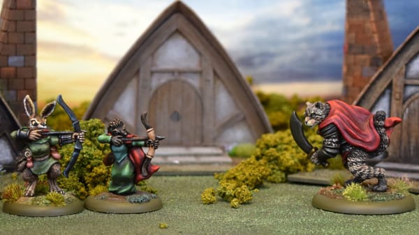 A photo of Burrows & Badgers miniatures with terrain showing two archers with a ferocious wildcat bearing down on them.